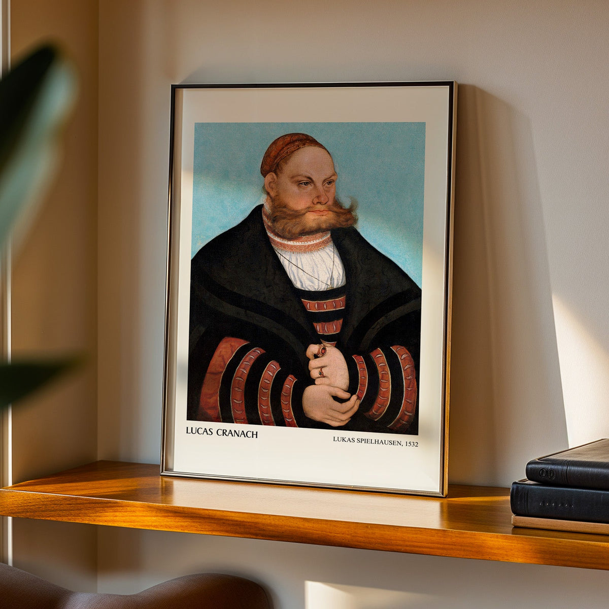 Bearded man portrait print in a black frame on a walnut shelf in evening light