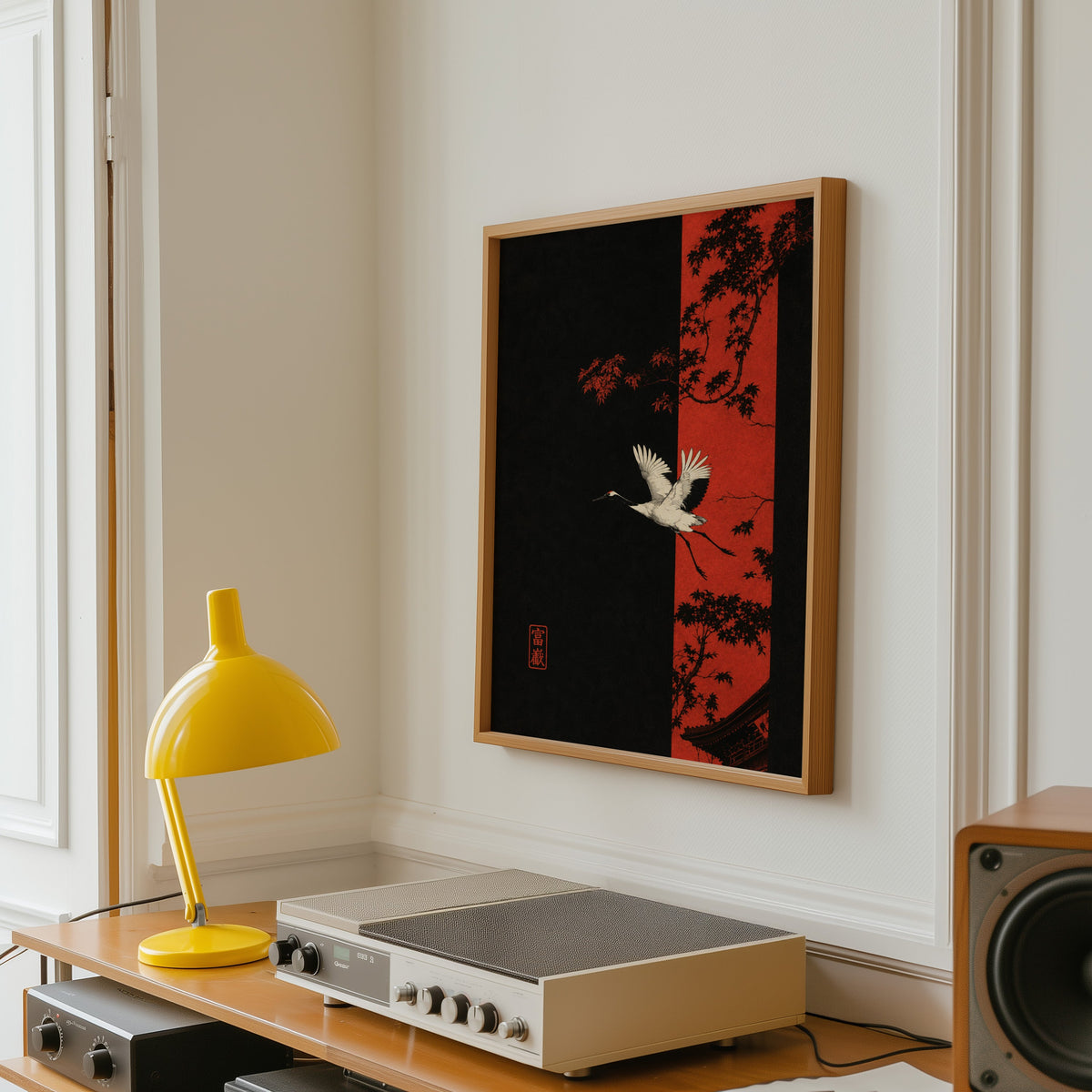 white crane and red maple print in an oak frame above a vintage hi-fi shelf with a yellow desk lamp
