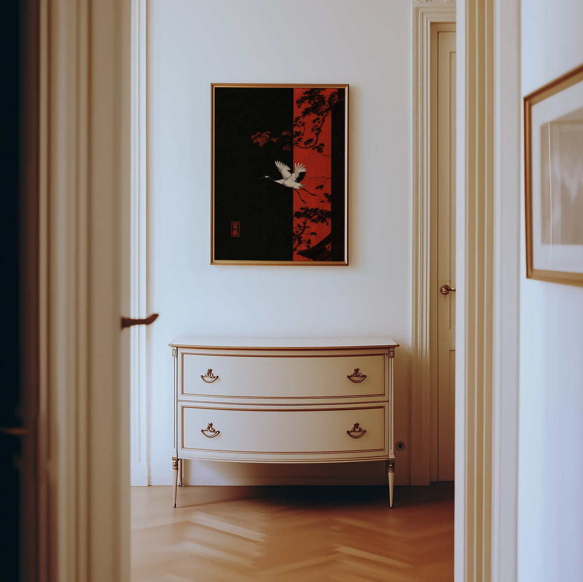 white crane and red maple print shown in a gold frame in a hallway above a cream dresser