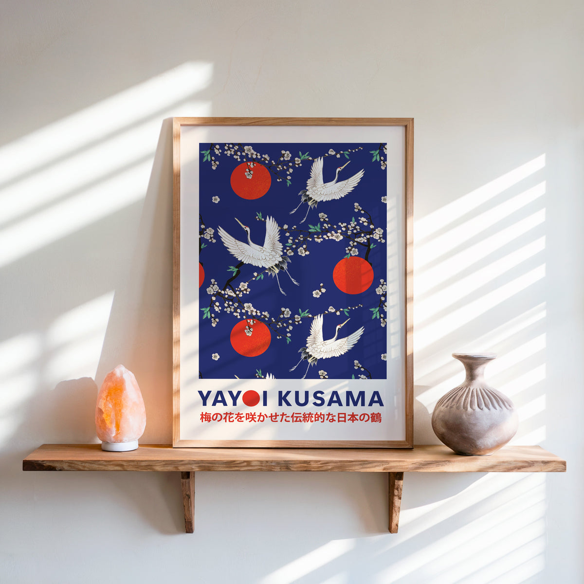 Yayoi Kusama inspired cranes and plum blossom on cobalt print in an oak frame on a live edge shelf beside a salt lamp