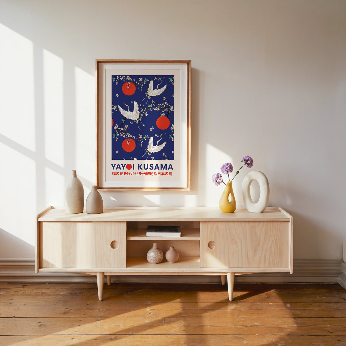 Yayoi Kusama inspired cranes and plum blossom on cobalt print in a wood frame with white mat over a media console