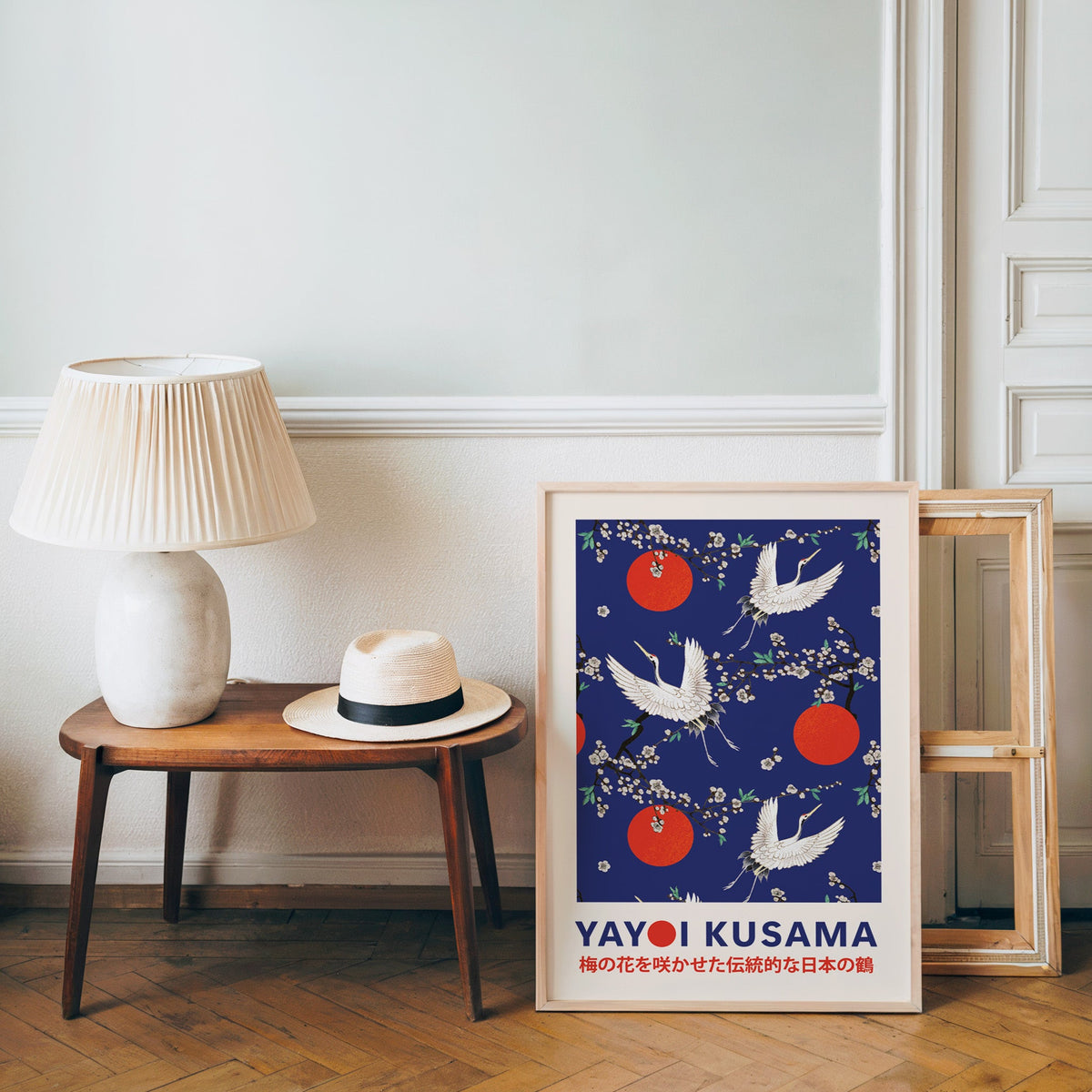 Yayoi Kusama inspired cranes and plum blossom on cobalt print in an oak frame over a bench with a panama hat