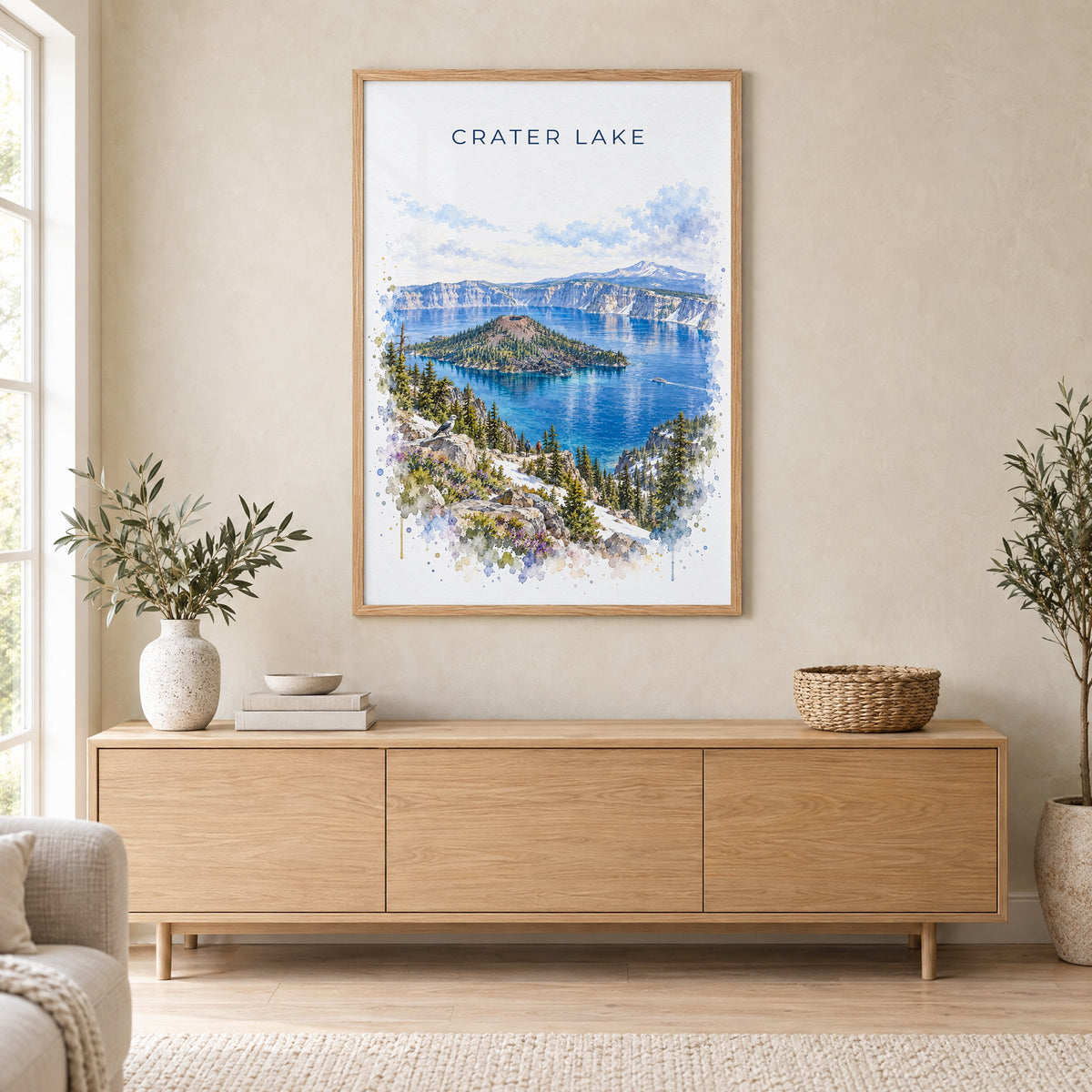 Crater Lake National Park watercolor print in an oak frame above a light wood sideboard in a Scandinavian living room