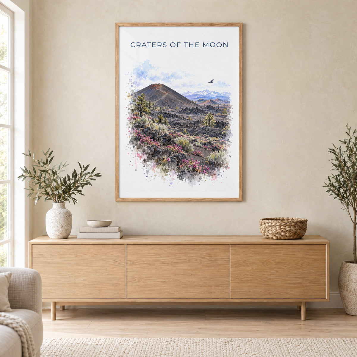 Craters of the Moon National Monument watercolor in an oak frame above a light wood sideboard in a Scandinavian living room