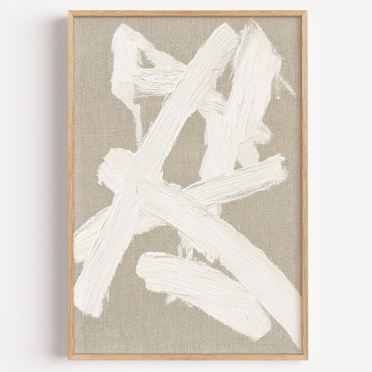 Cream impasto crossed strokes on linen print in a light oak frame on a plain white wall
