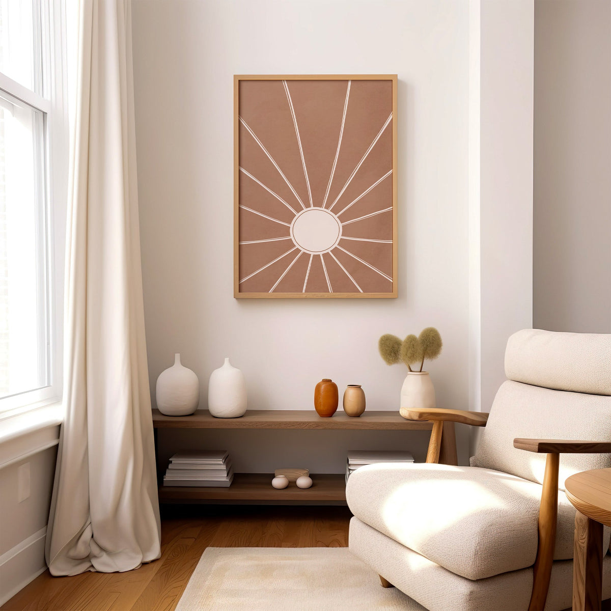 Cream sunburst rays on terracotta boho print in an oak frame above a wood console shelf by a cream boucle armchair