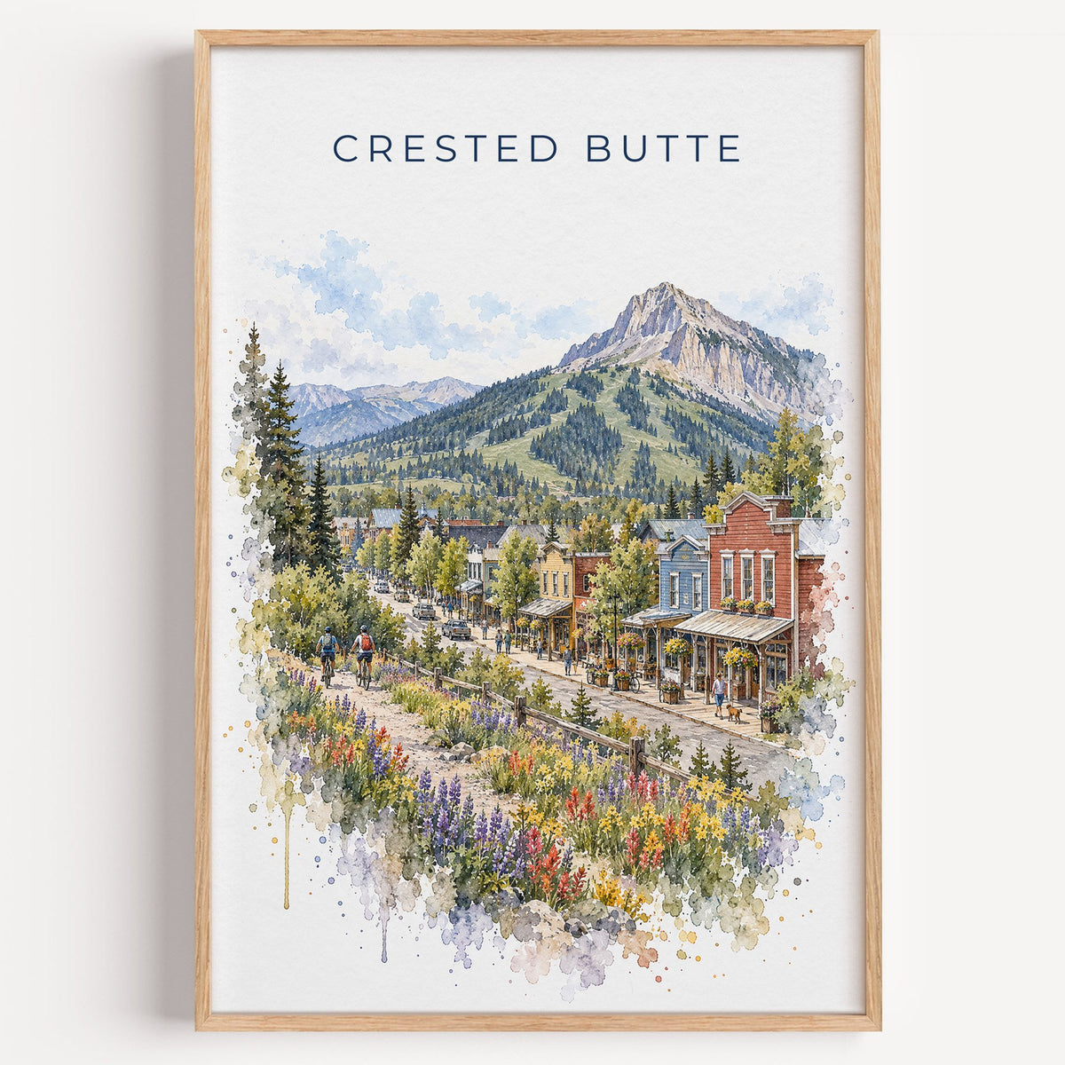 Crested Butte watercolor print in a light oak frame on a plain white wall