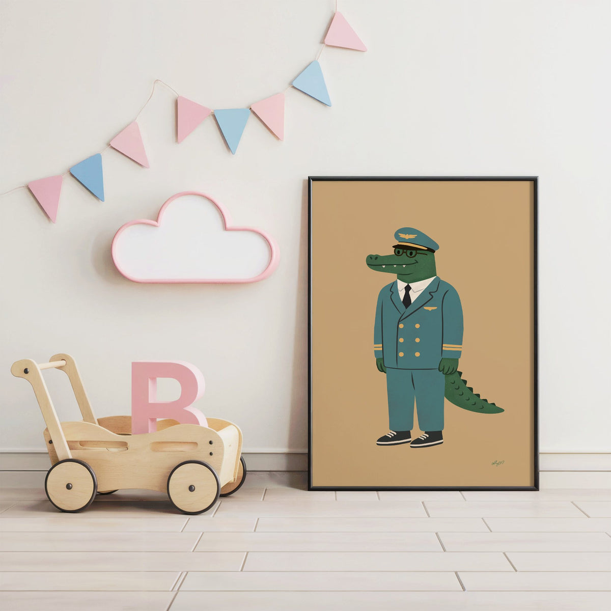 Crocodile in teal pilot uniform nursery print in a black frame under pastel bunting by a wooden baby walker
