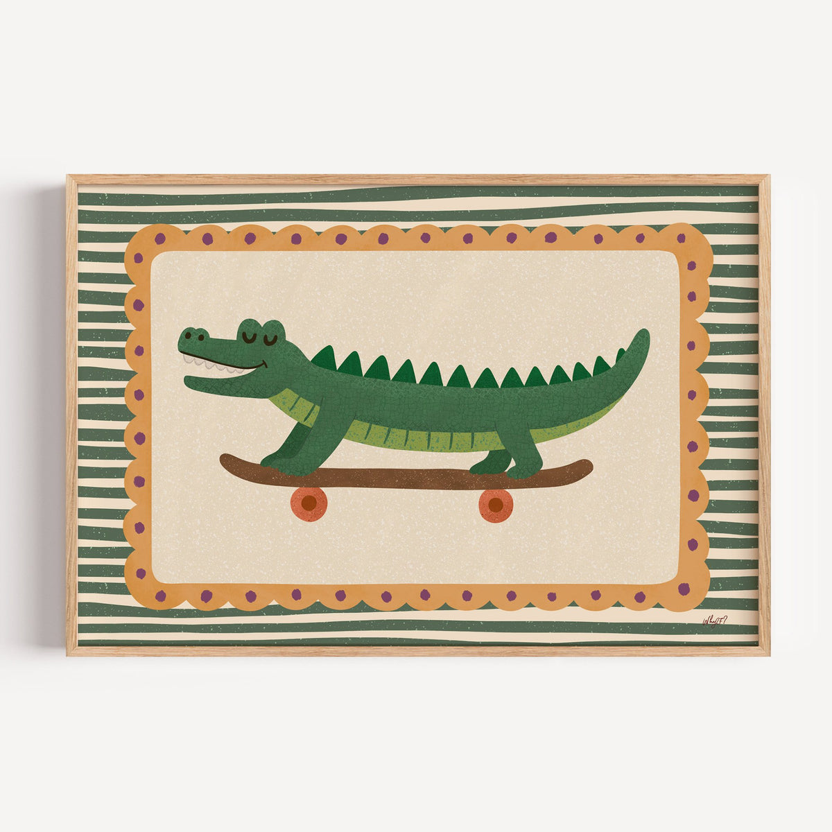 Smiling crocodile on skateboard nursery print in a light oak frame on a plain white wall