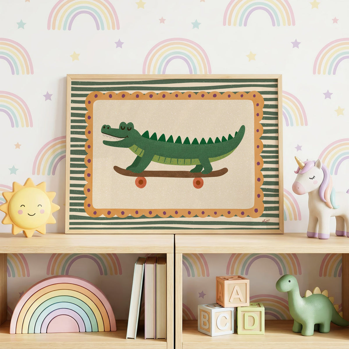 Smiling crocodile on skateboard nursery print in an oak frame on a toy shelf against rainbow wallpaper