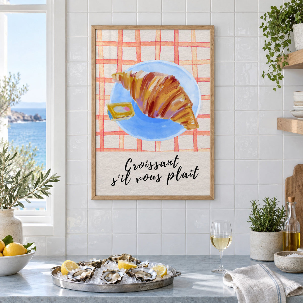 Croissant s'il vous plait blue plate print in an oak frame on white tiles above a marble counter with oysters and lemons by a sea view