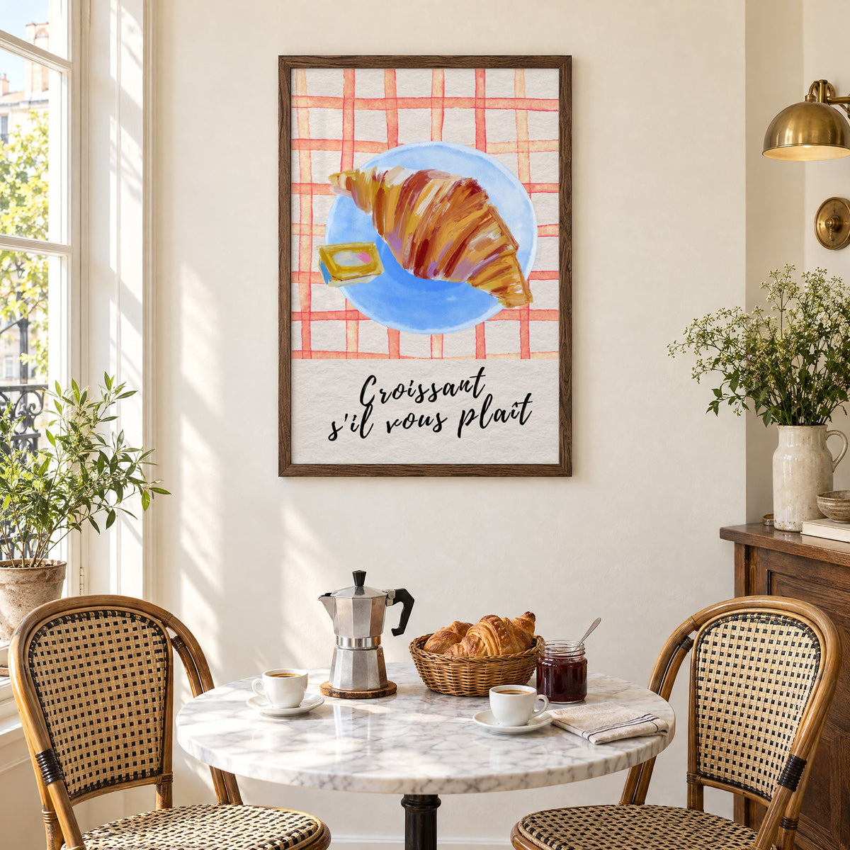 Croissant s'il vous plait blue plate print in a walnut frame above a marble bistro table with croissants and rattan chairs