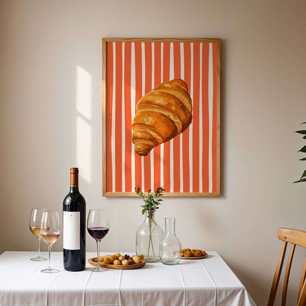 Painted croissant print in an oak frame above a table laid with red wine and glasses