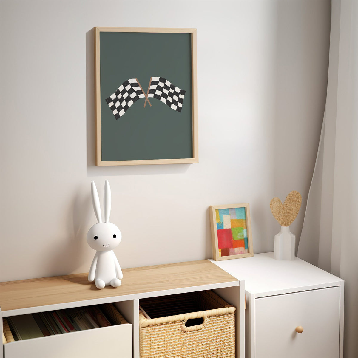 Crossed checkered racing flags nursery print in an oak frame above a kids cubby shelf with a woven basket and bunny lamp