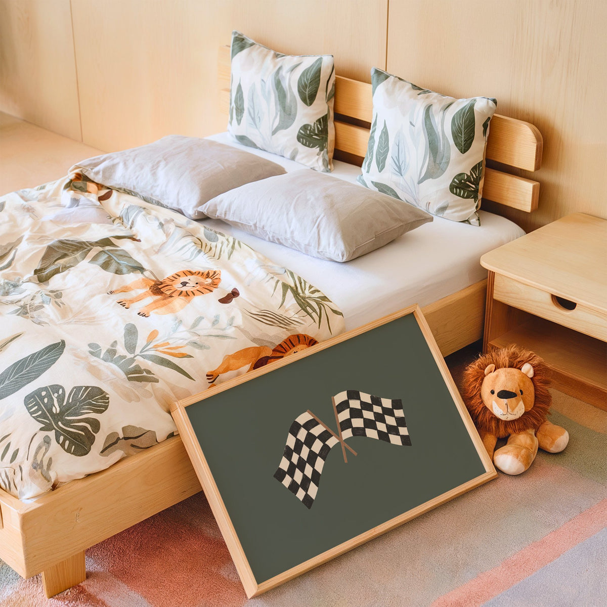 Landscape crossed checkered racing flags nursery print in an oak frame leaning on a kids bed by a lion plush