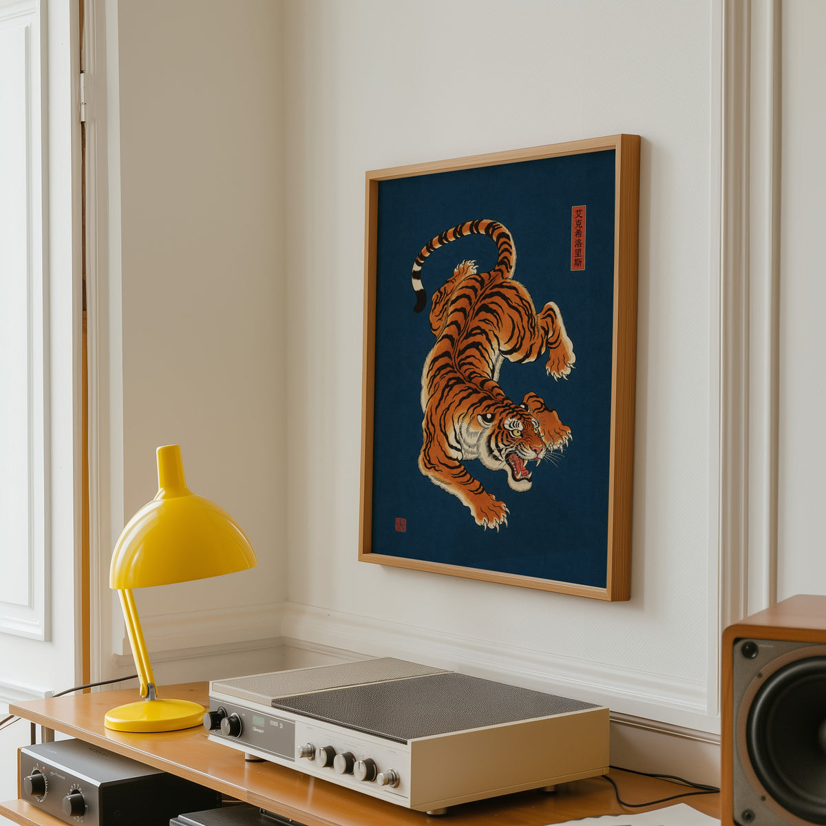 orange tiger on navy blue print in an oak frame above a vintage hi-fi shelf with a yellow desk lamp
