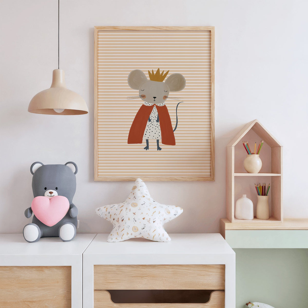 Crowned mouse red cape nursery print in an oak frame above a white dresser with a star pillow and house shelf