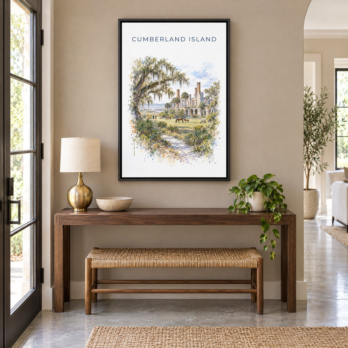 Cumberland Island watercolor print as a black floater canvas above a walnut console and woven bench in an entryway