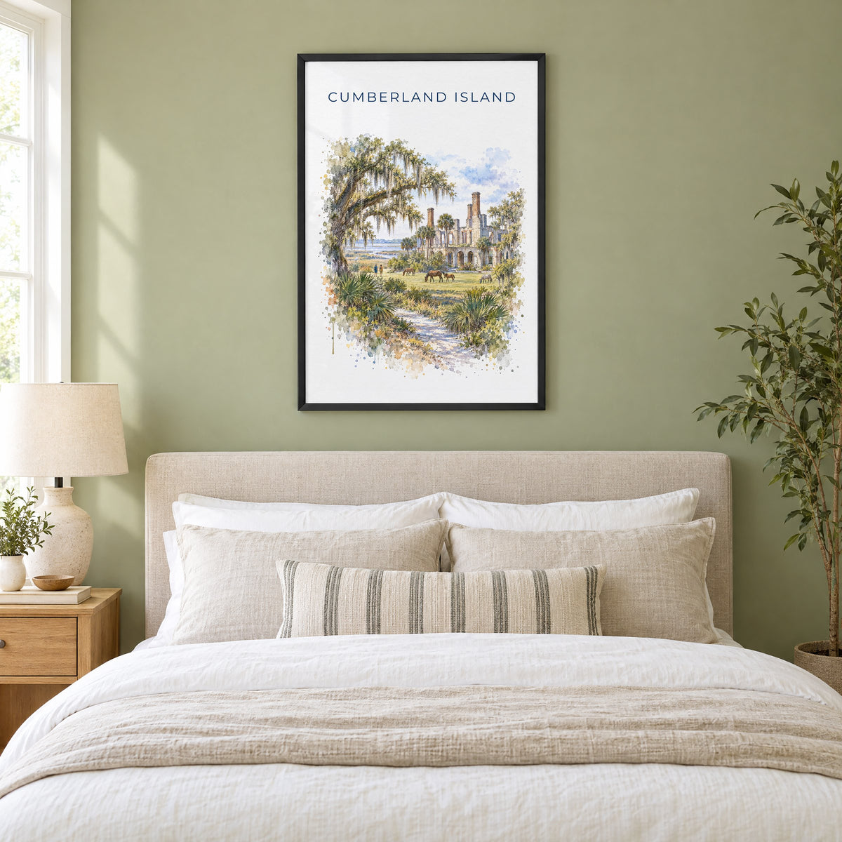 Cumberland Island watercolor print in a black frame above an upholstered headboard in a sage green bedroom