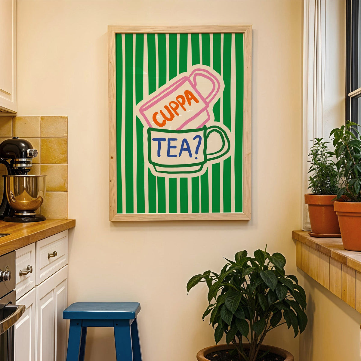 Cuppa tea print in a wood frame on a yellow tiled kitchen wall