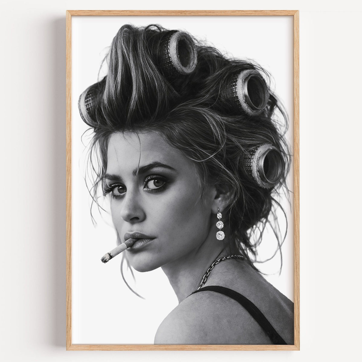 Woman in big curlers looking over shoulder print in a light oak frame on a plain white wall