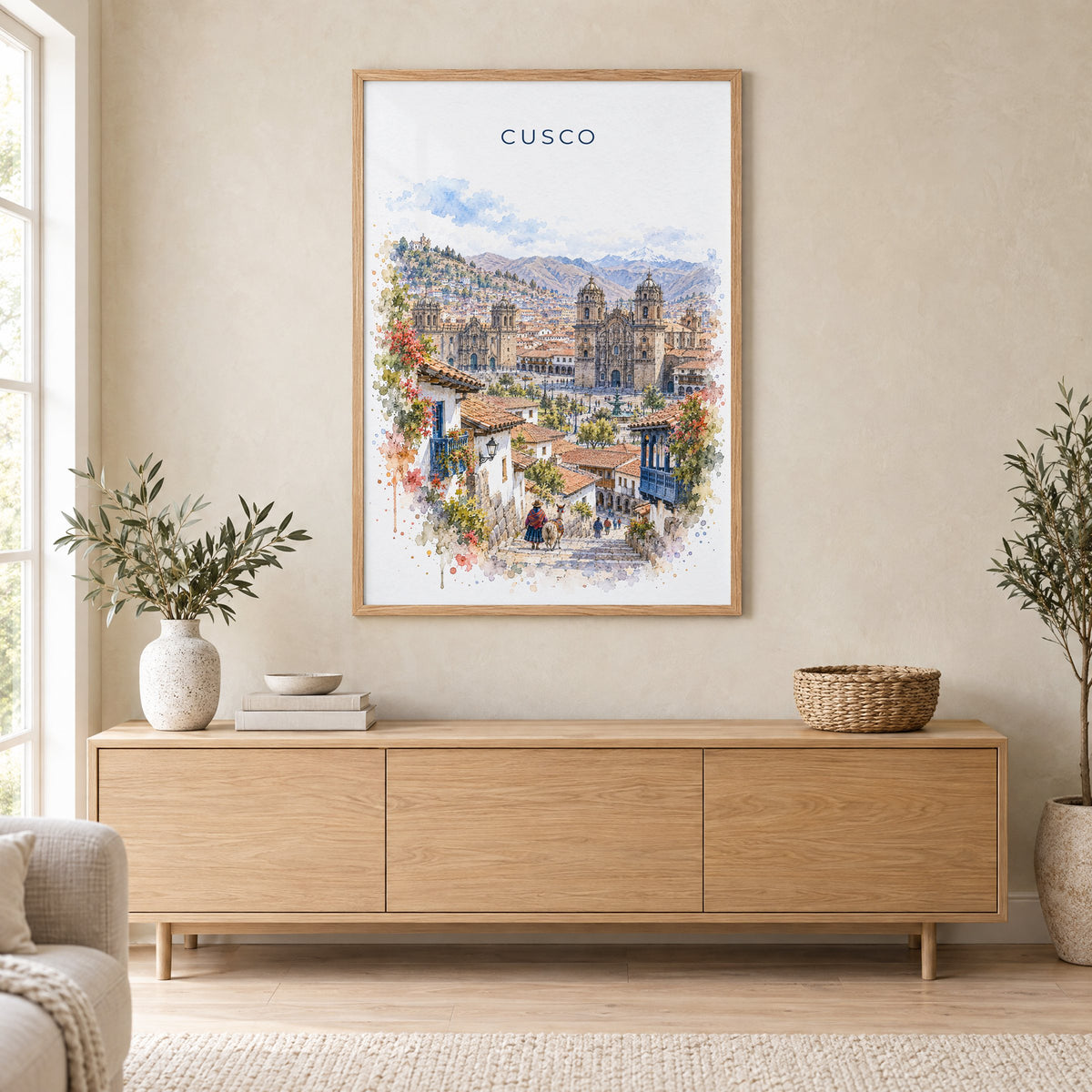 Cusco watercolor print in an oak frame above a light wood sideboard in a Scandinavian living room