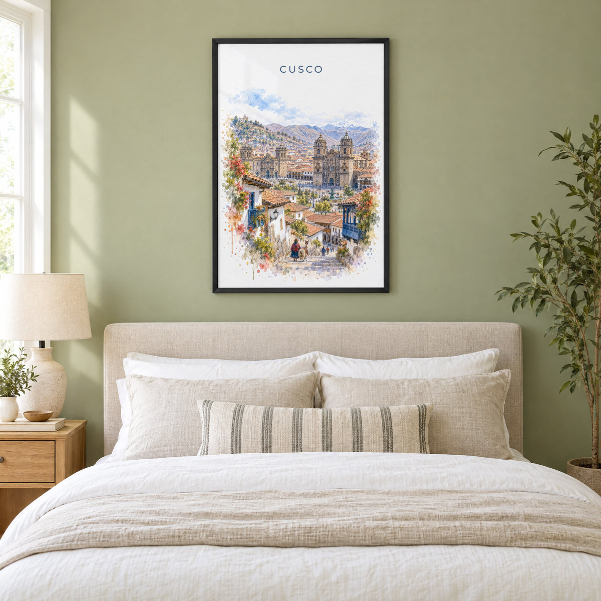 Cusco watercolor print in a black frame above an upholstered headboard in a sage green bedroom