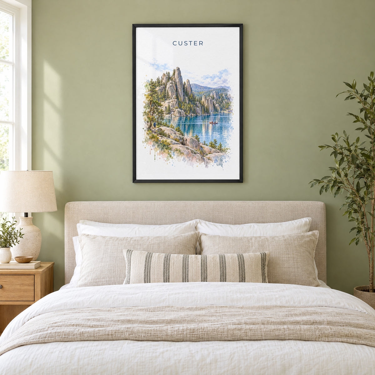 Custer State Park watercolor print in a black frame above an upholstered headboard in a sage green bedroom