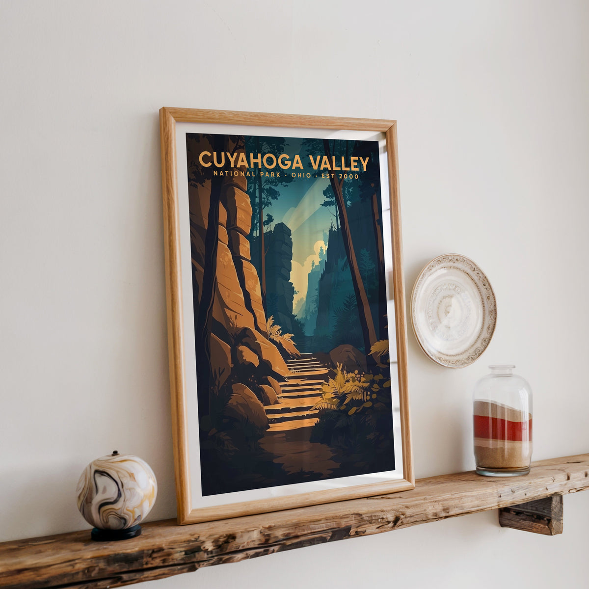 Cuyahoga Valley print in an oak frame on a rustic wood shelf with ceramics and a sand jar