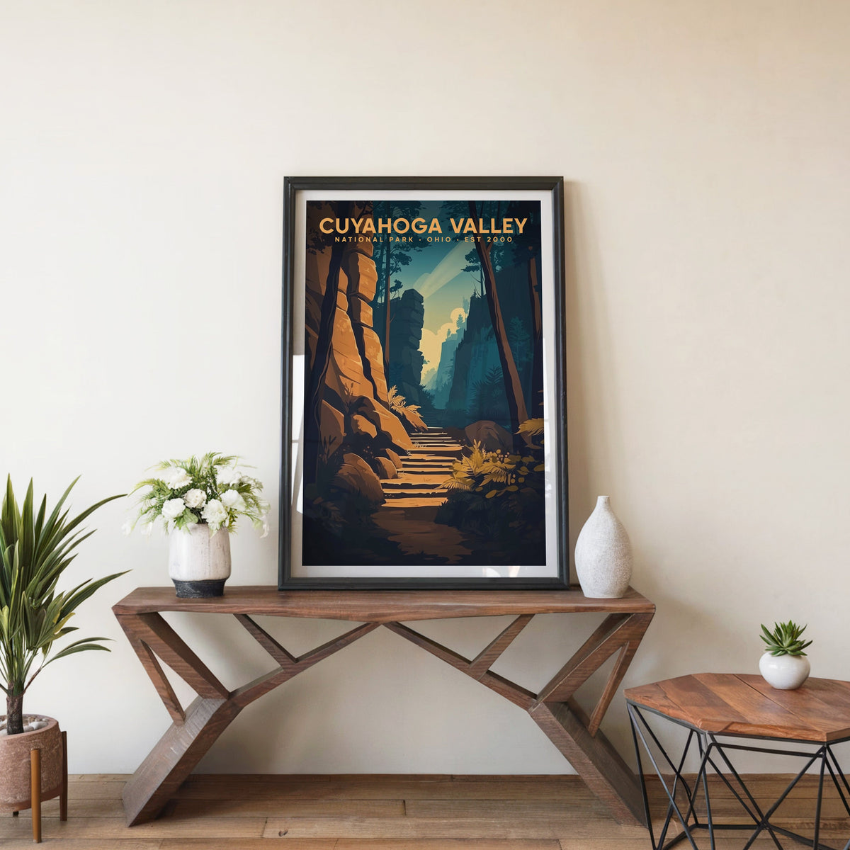 Cuyahoga Valley poster in a black frame on an entryway console table with white flowers