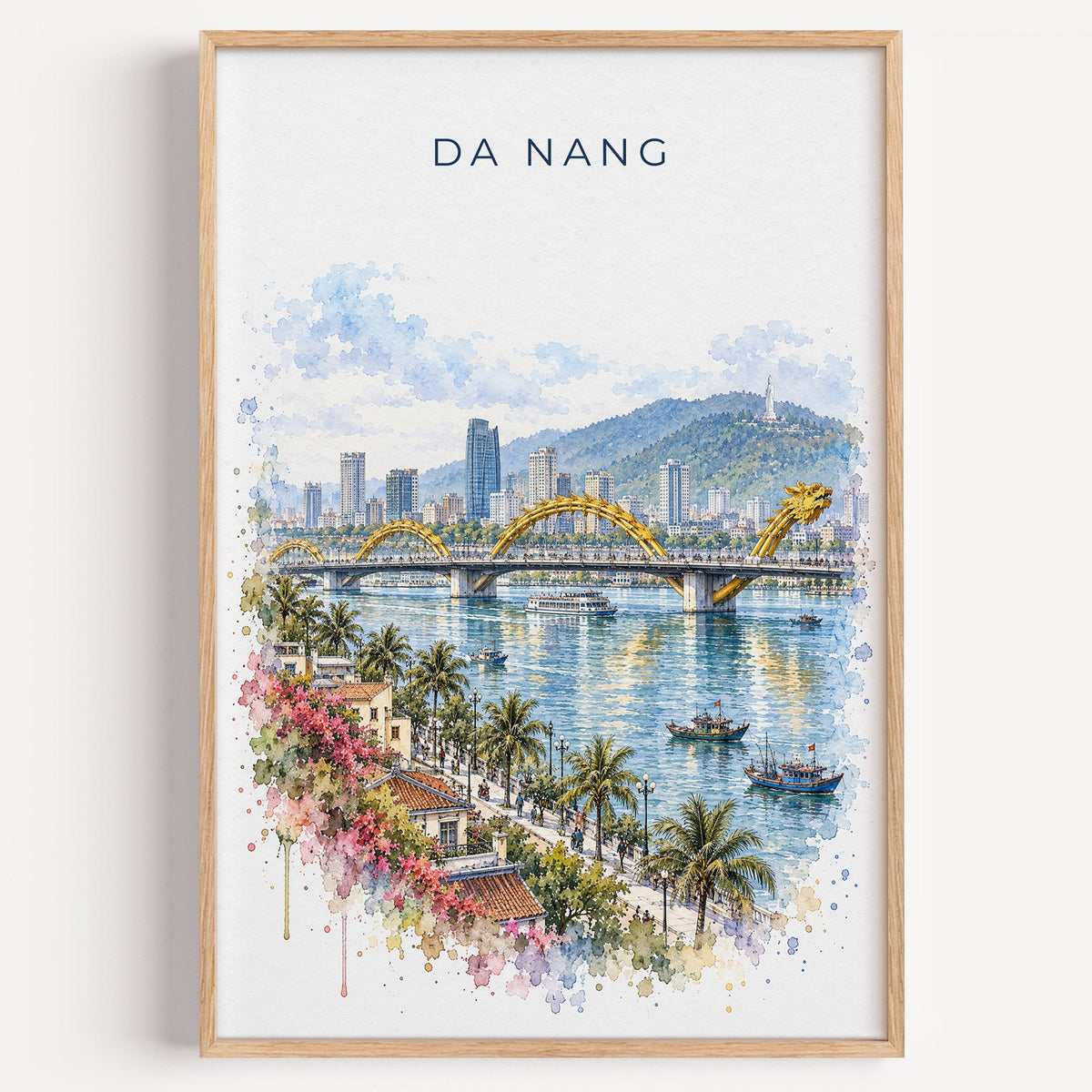 Da Nang watercolor print in a light oak frame on a plain white wall