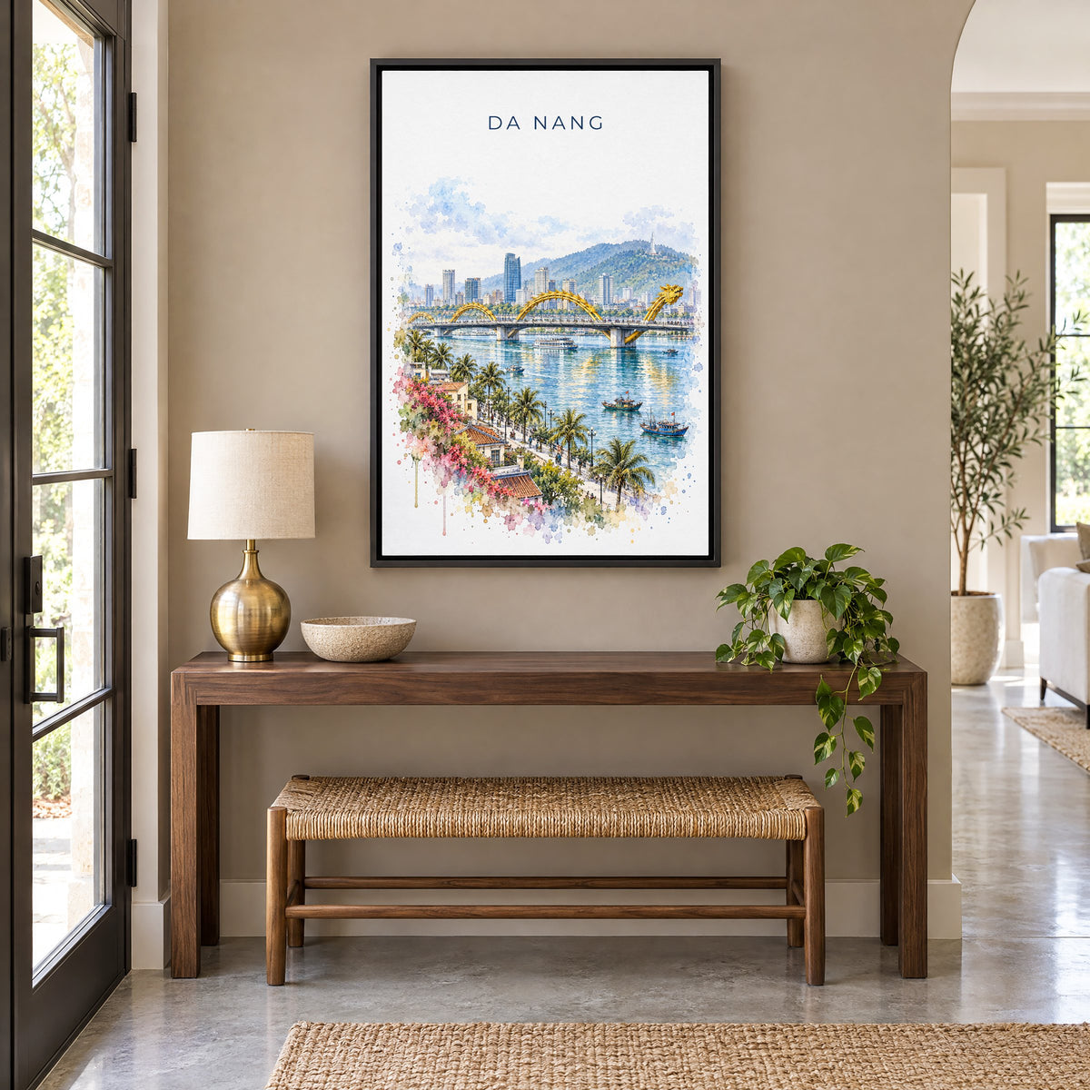Da Nang watercolor print as a black floater canvas above a walnut console and woven bench in an entryway