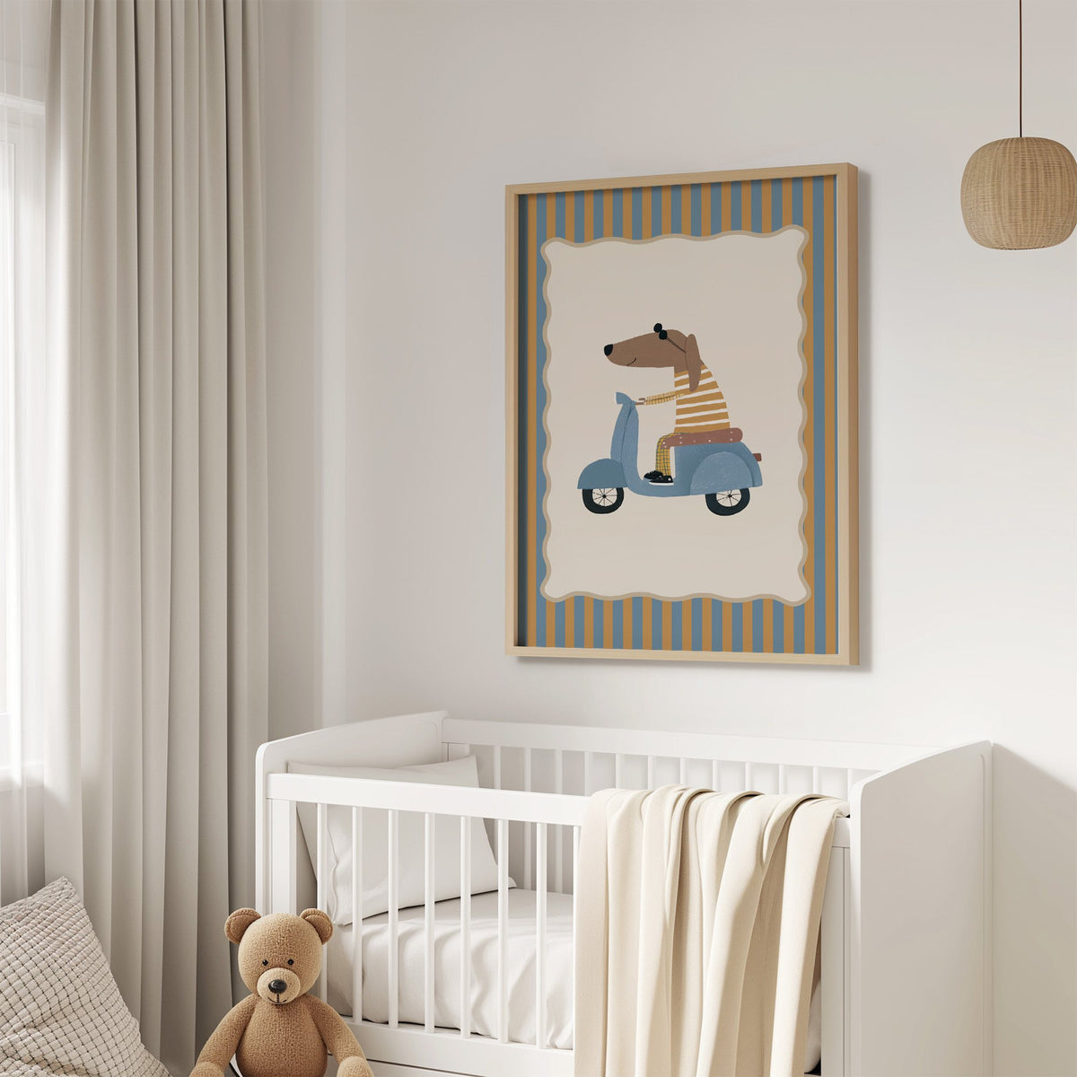 Dachshund on blue scooter nursery print in an oak frame above a white crib with a teddy bear