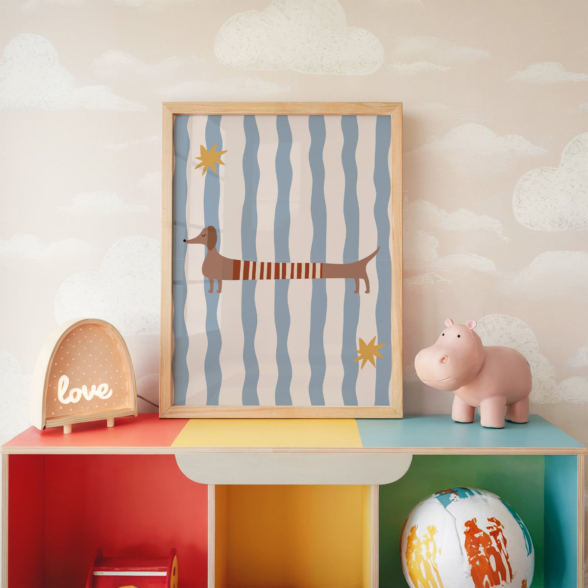 Dachshund red striped sweater nursery print in an oak frame on a rainbow toy shelf against cloud wallpaper