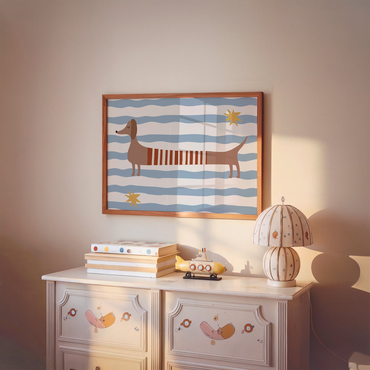 Landscape dachshund red striped sweater nursery print in a cherry wood frame above a painted dresser and lamp