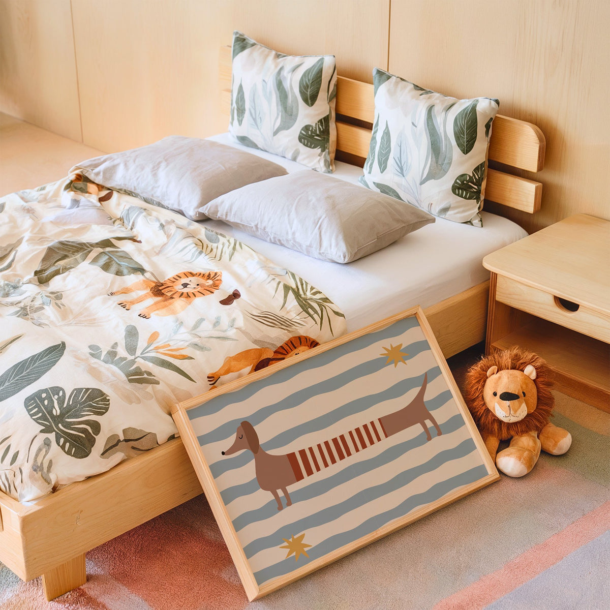 Landscape dachshund red striped sweater nursery print in an oak frame leaning on a kids bed by a lion plush