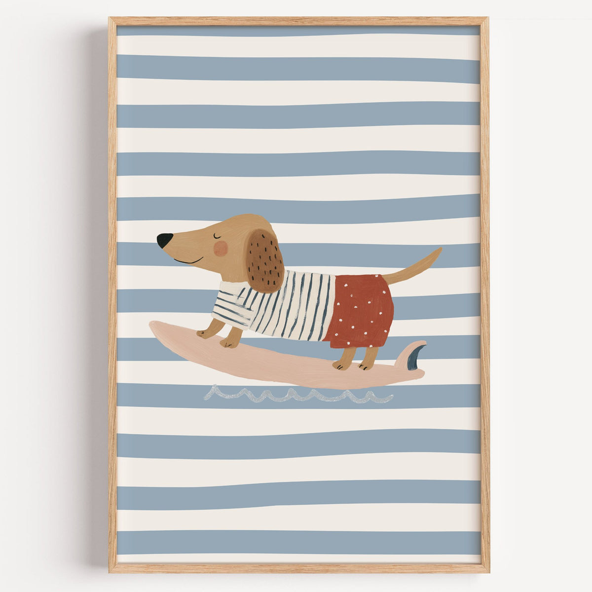 Dachshund on pink surfboard nursery print in a light oak frame on a plain white wall