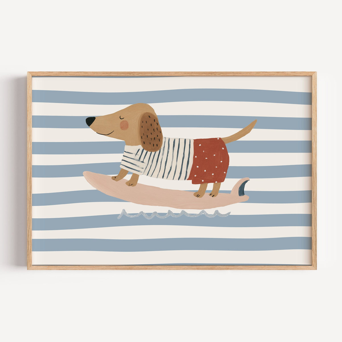 Landscape dachshund on pink surfboard nursery print in a light oak frame on a plain white wall