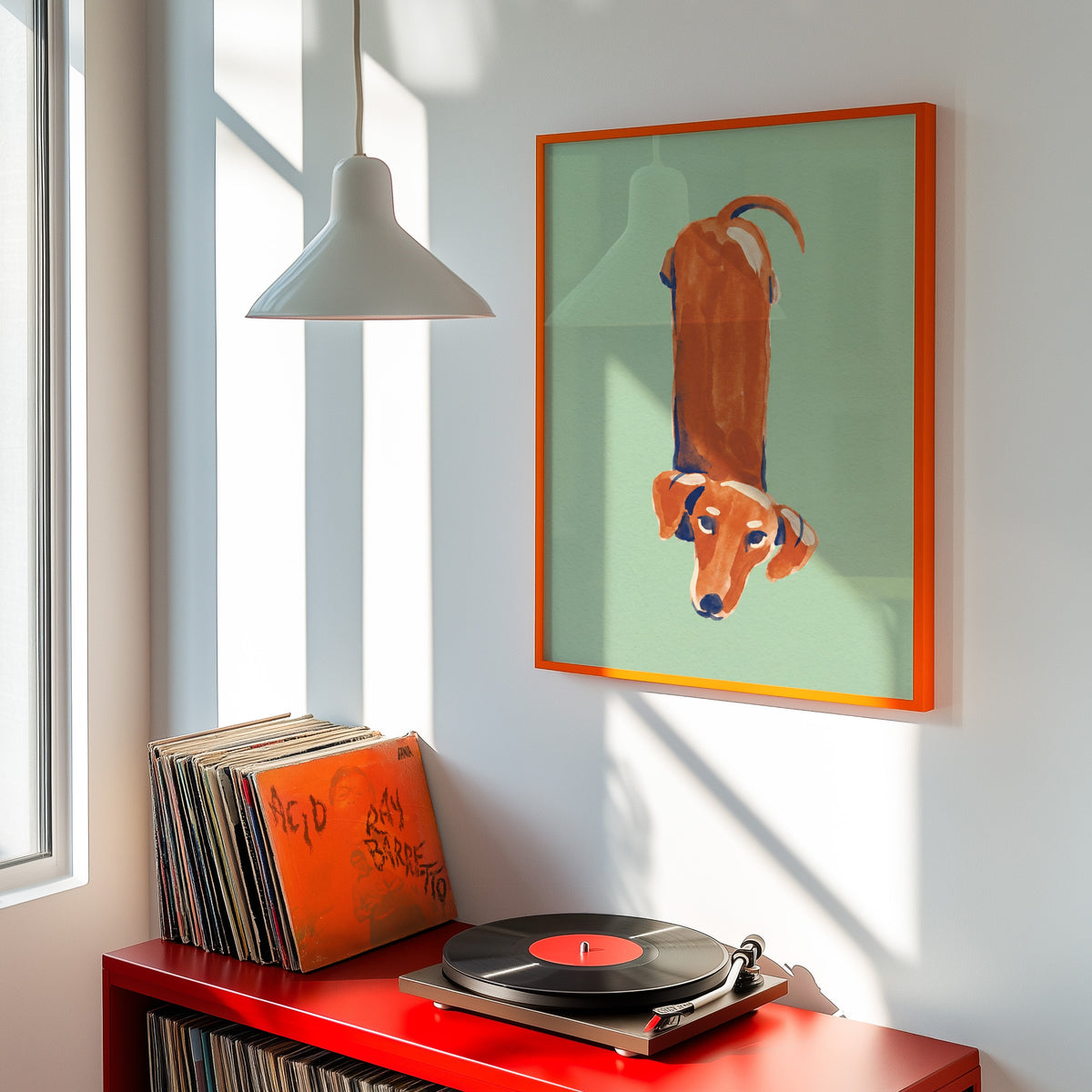 Mint green dachshund print shown in an orange frame above a red record cabinet and turntable