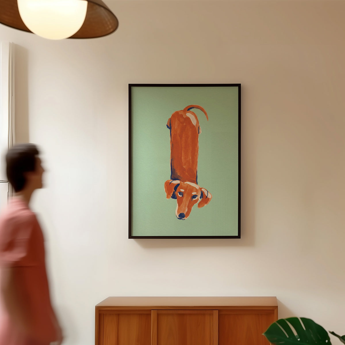 Funny dachshund print in a black frame in a hallway under a rattan pendant