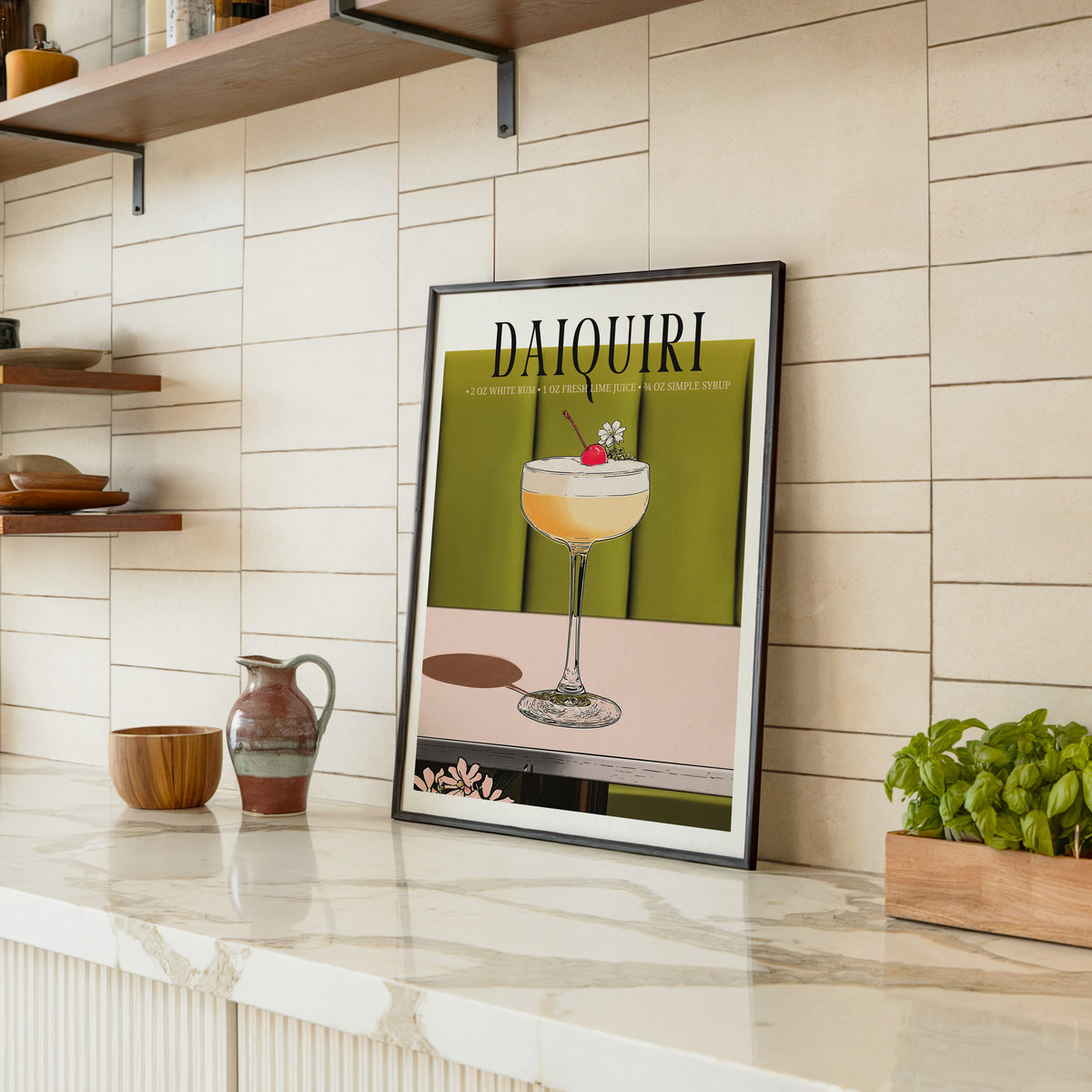 Daiquiri recipe print in a black frame leaning on a marble counter in a tiled kitchen