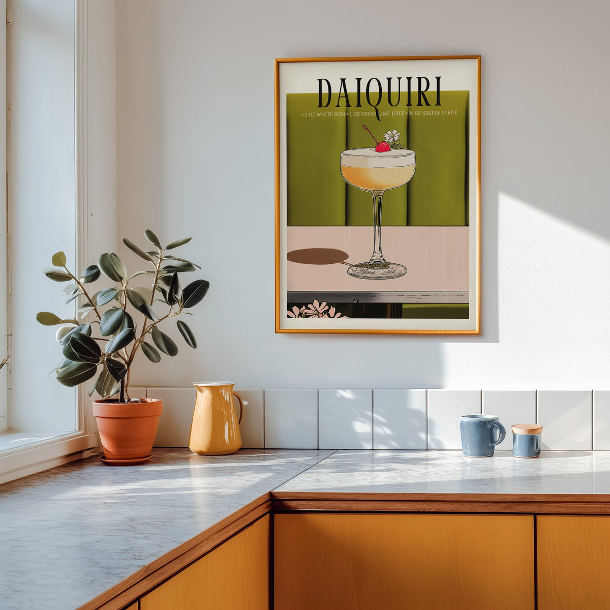 Daiquiri recipe print shown in a gold frame above a marble counter in a tan kitchen