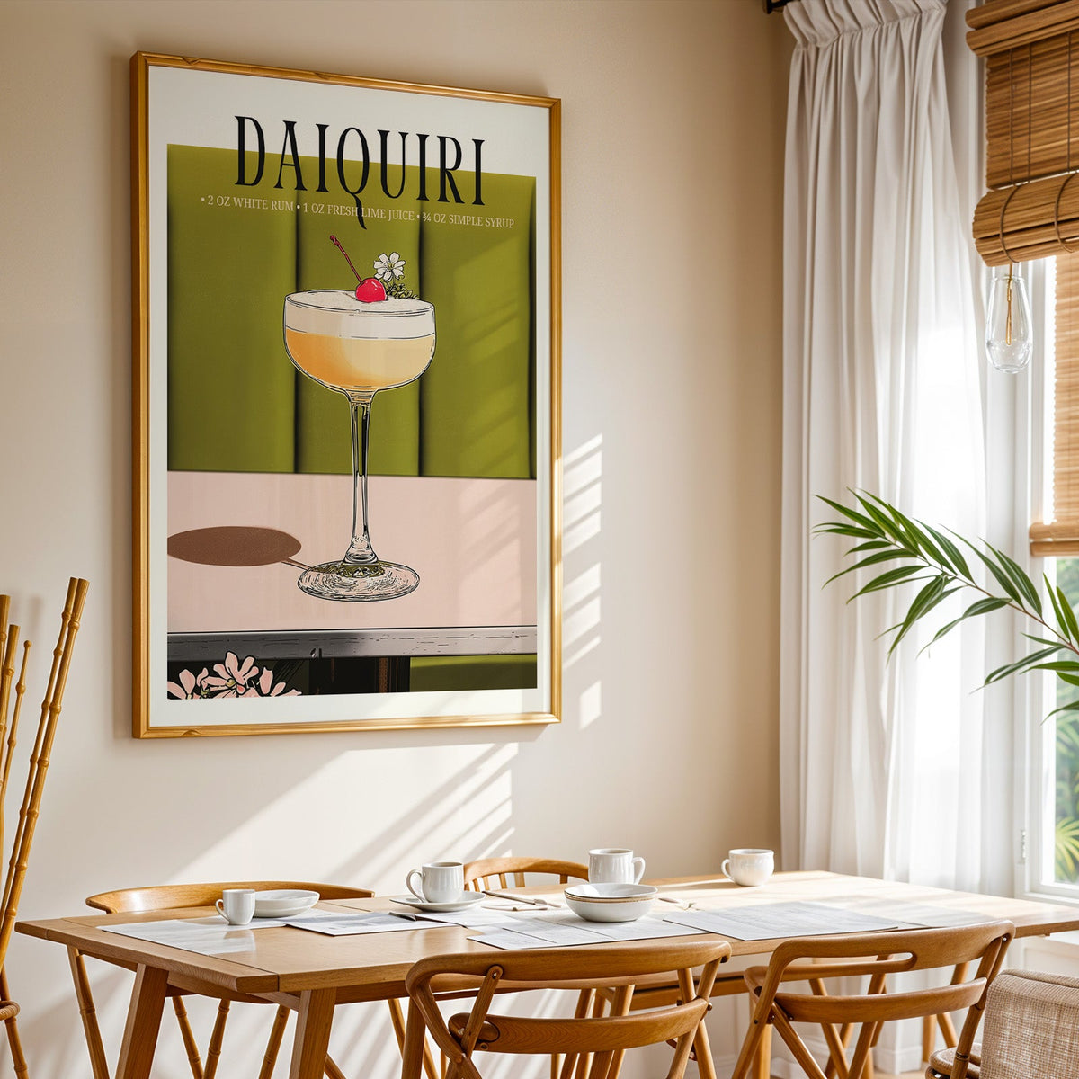 Daiquiri recipe print shown in a gold frame above a breakfast table by a curtained window