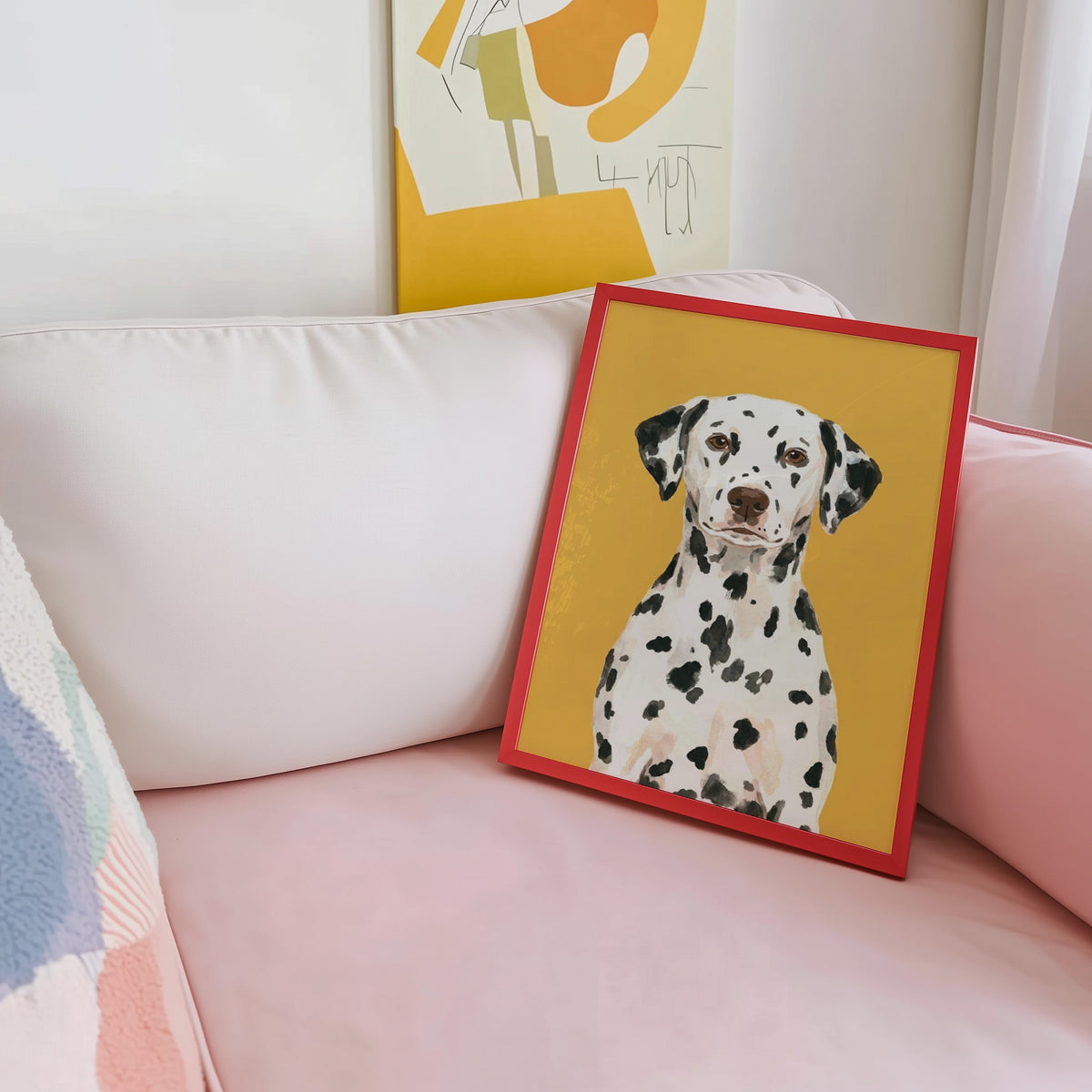 Spotted dog portrait print shown in a red frame leaning on a blush pink sofa
