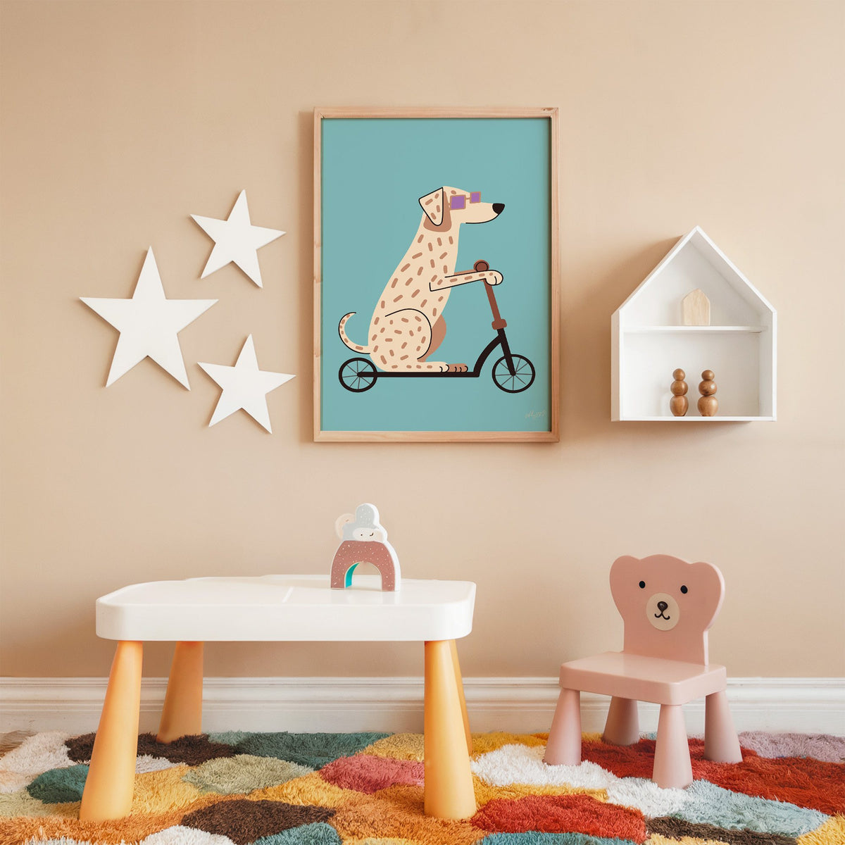 Dalmatian on scooter with purple glasses nursery print in an oak frame on a peach wall above a kids table with wall stars