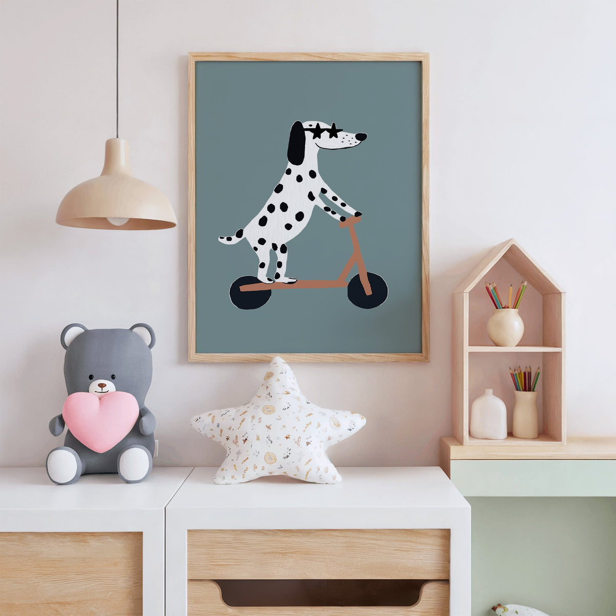 Dalmatian on scooter star glasses nursery print in an oak frame above a white dresser with a star pillow and house shelf