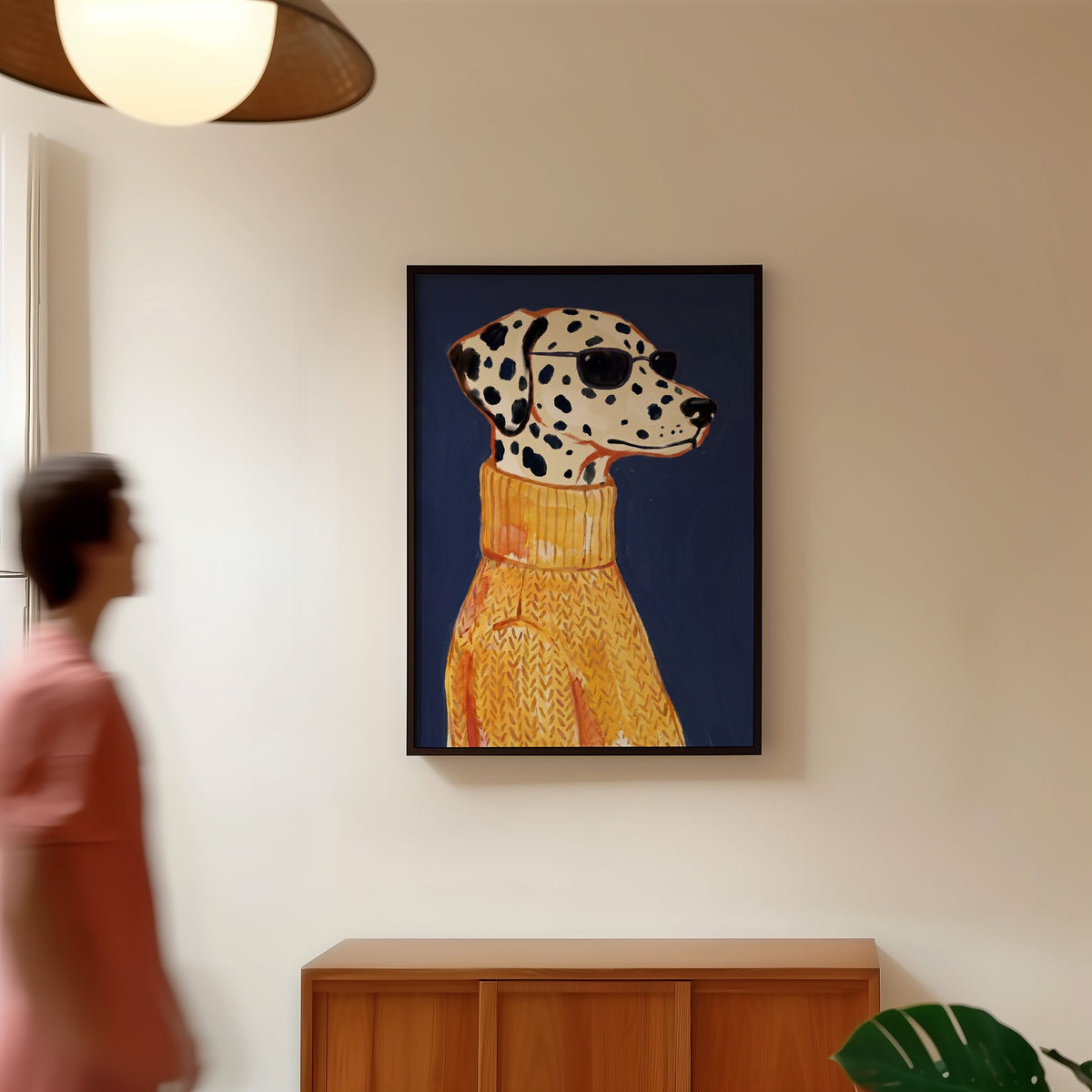 Navy and mustard dog print in a black frame in a hallway under a rattan pendant