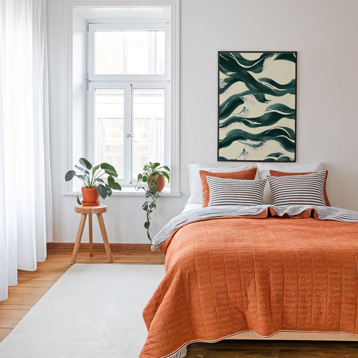 Dark green brushstroke waves abstract print in a thin black frame above a bed with a rust orange quilt