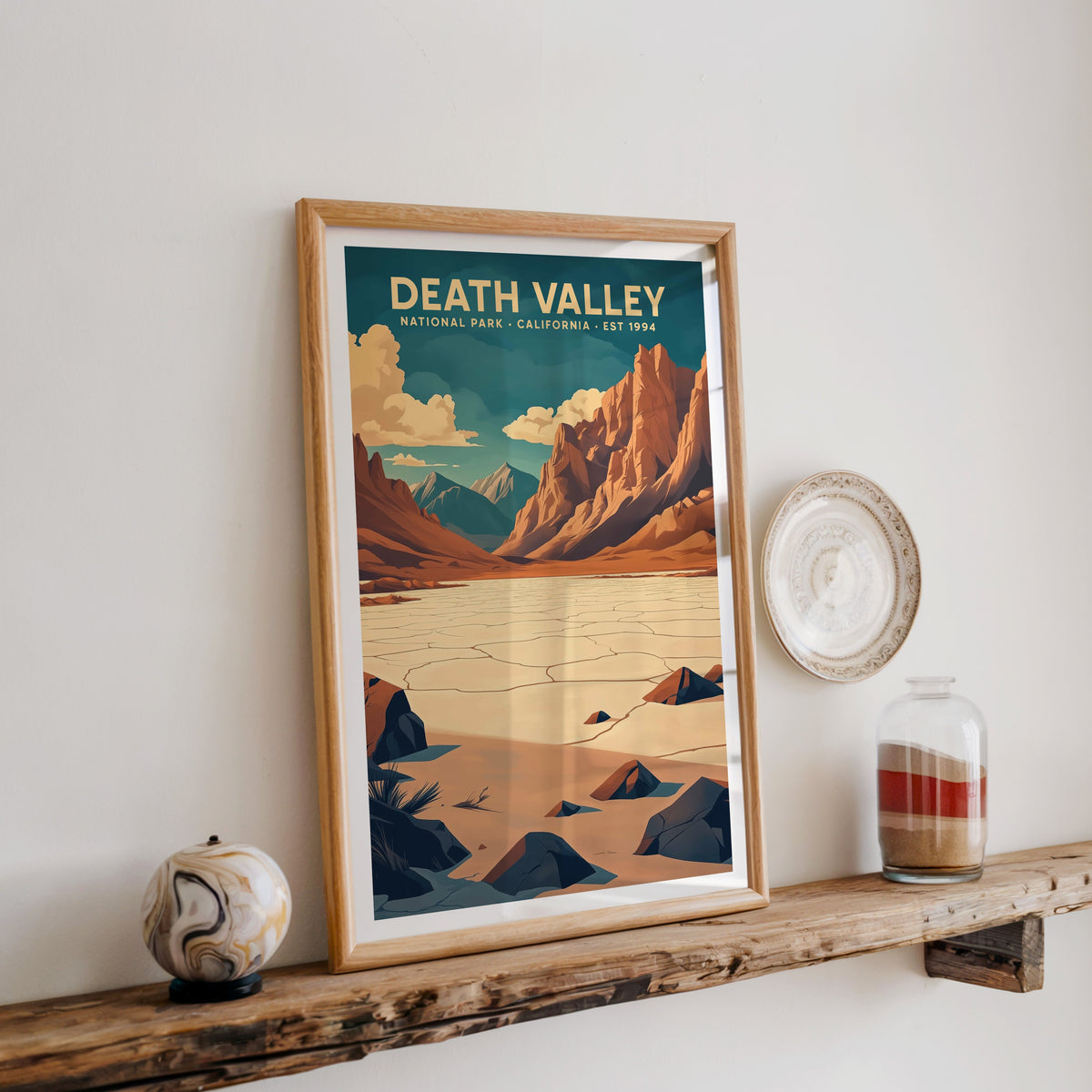 Death Valley National Park print in an oak frame on a rustic wood shelf with ceramics