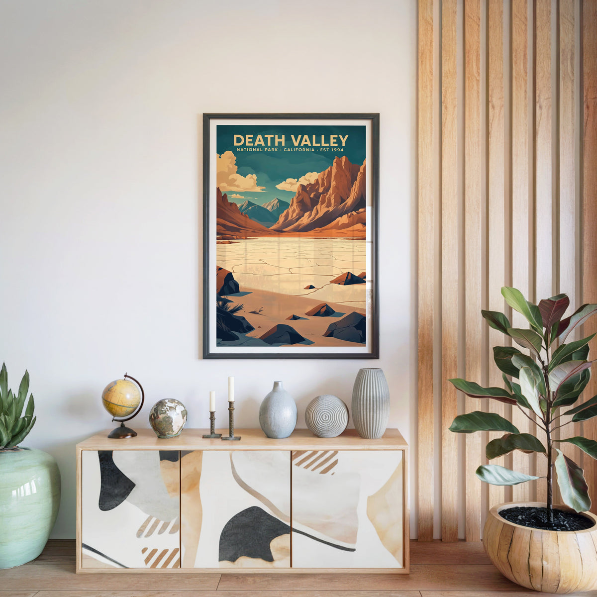 Death Valley National Park print in a black frame above a light wood sideboard with a globe